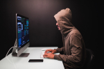 young-male-hacker-dark-room-writing-code-using-computer-virus-program-cyber-attack_1.jpg