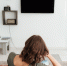 back-view-woman-sitting-sofa-watching-tv-home_1.jpg - GorodnaBire.Ru